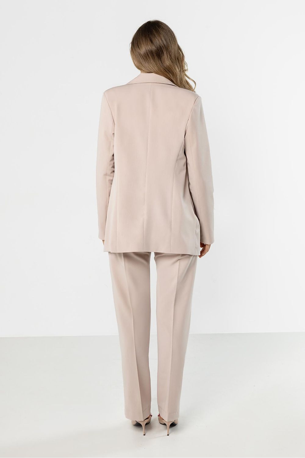 Person wearing a beige suit on a white background