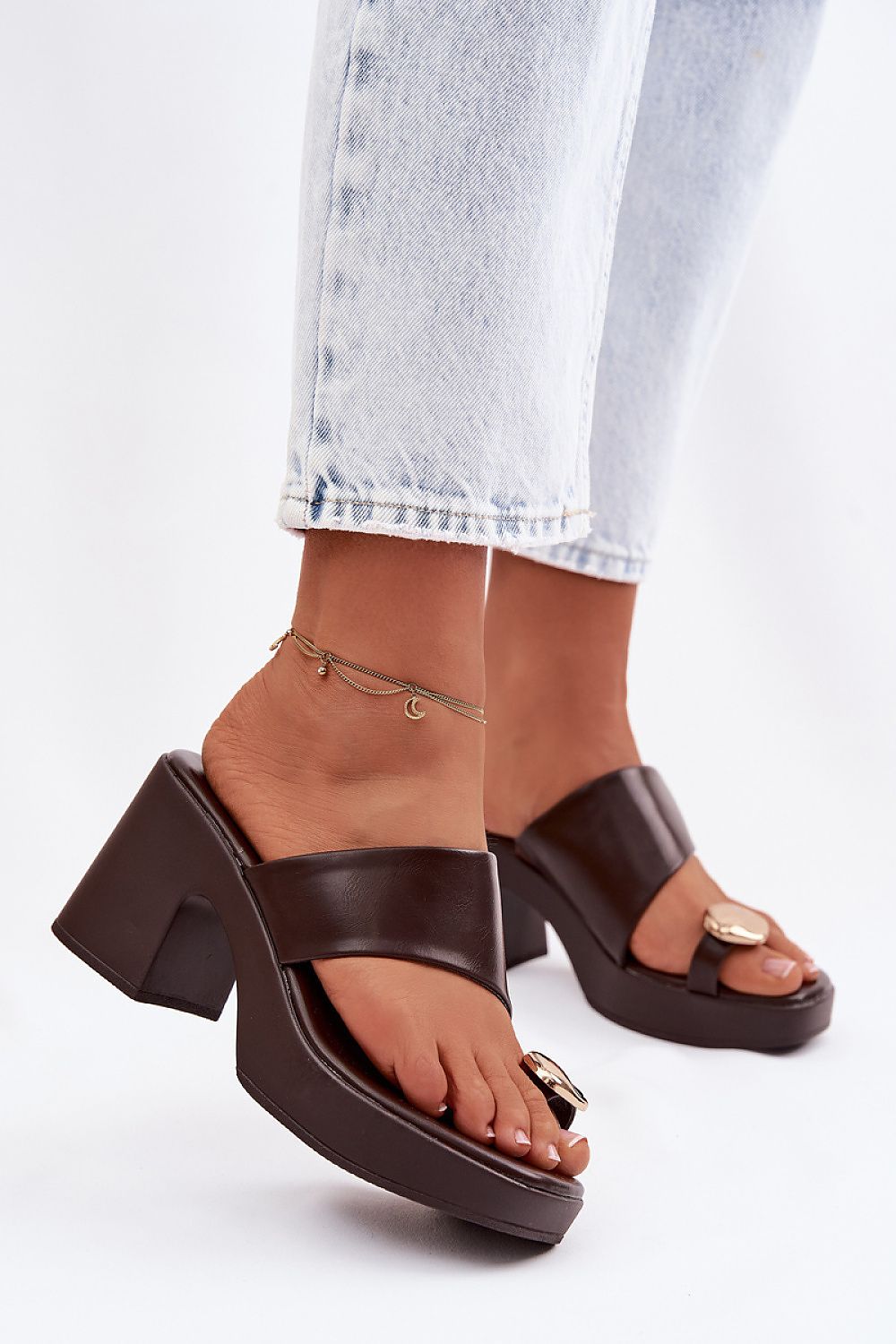 Brown platform sandals worn with light blue jeans on a white background