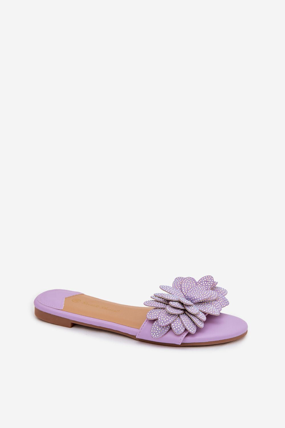 Purple flat sandal with a decorative flower on a white background