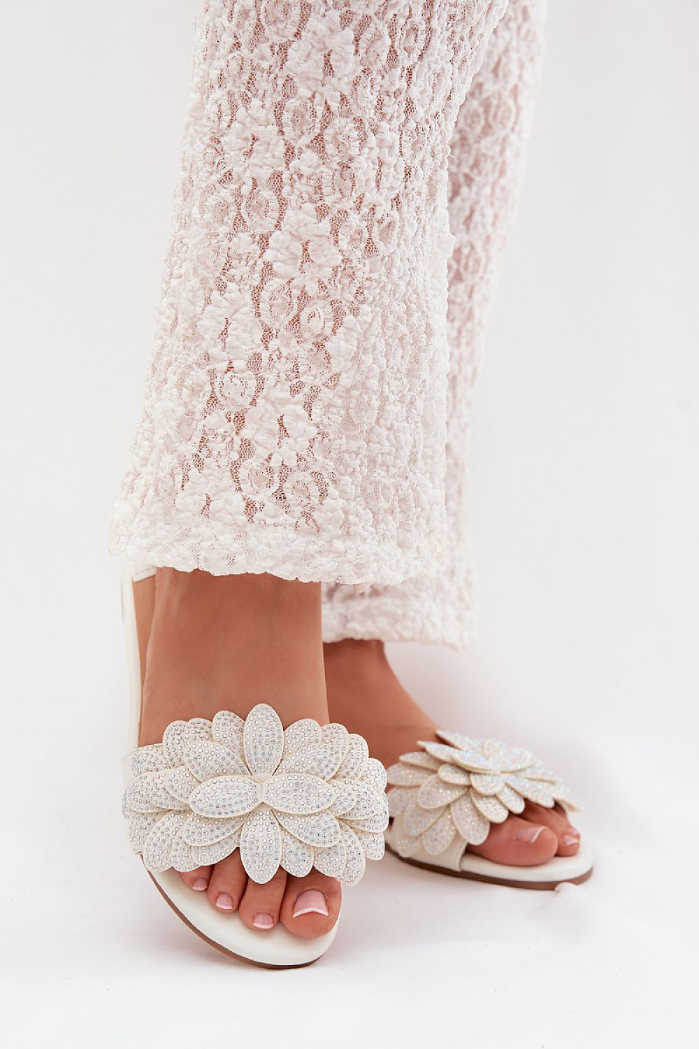 White lace dress with floral sandals on a white background
