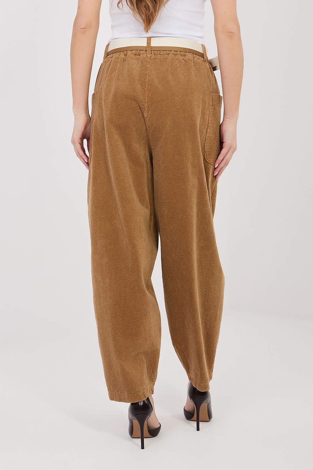 Brown pants worn by a person on a white background