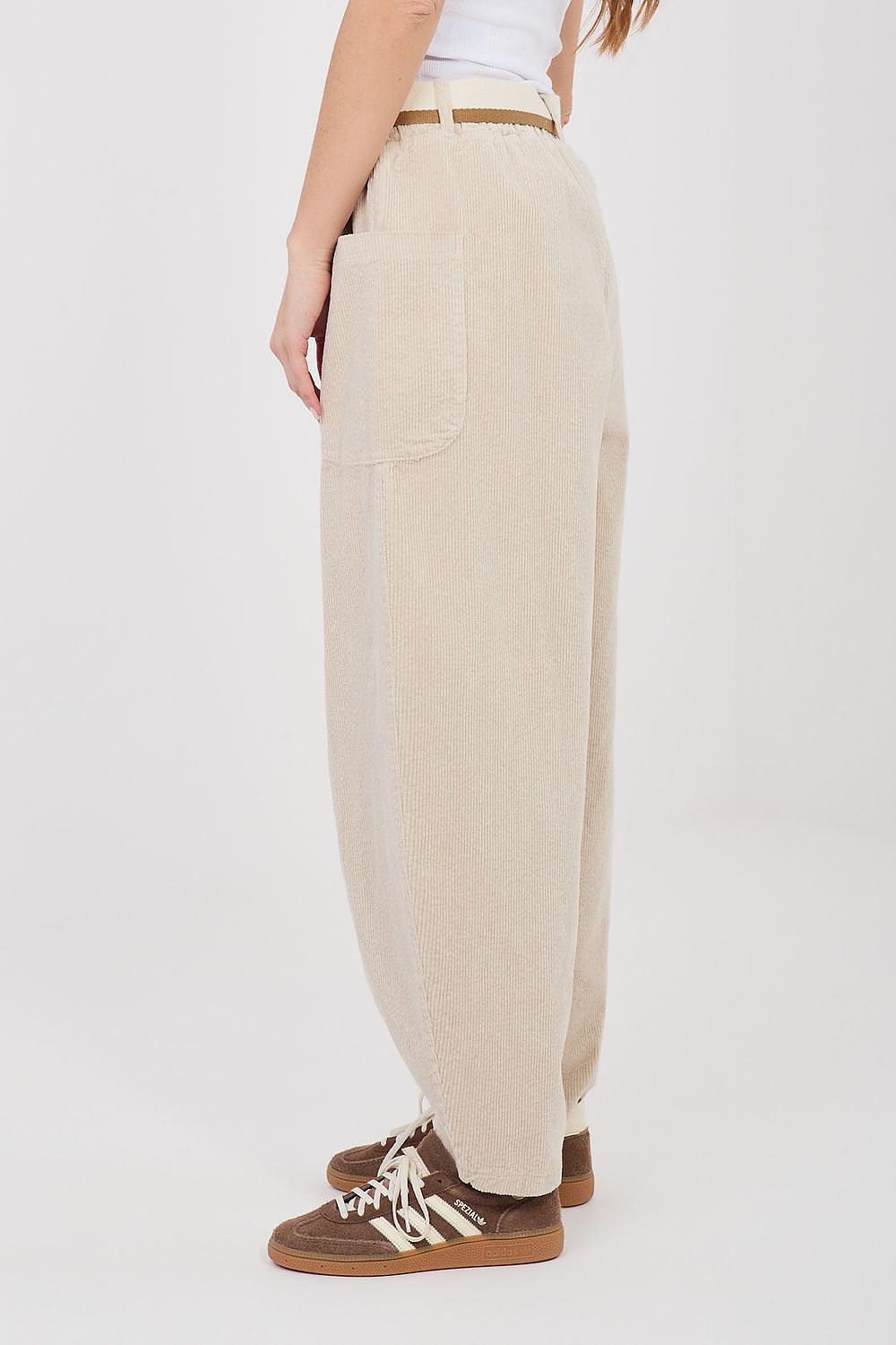 Beige pants worn by a person on a white background