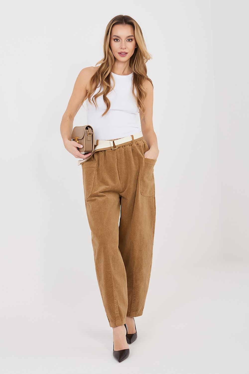 Woman wearing brown pants and a white top on a white background