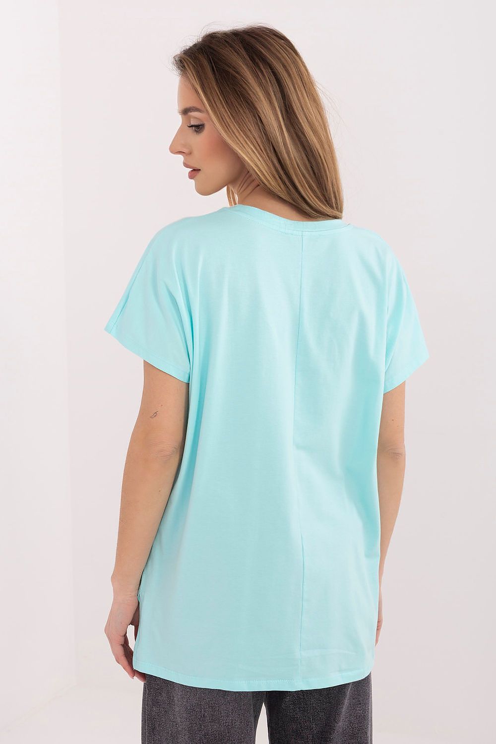 Woman wearing a light blue t-shirt against a plain background