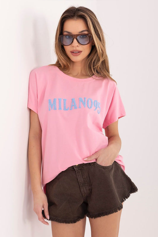 Woman wearing a pink t-shirt with 'MILANOS' text and brown shorts on a white background