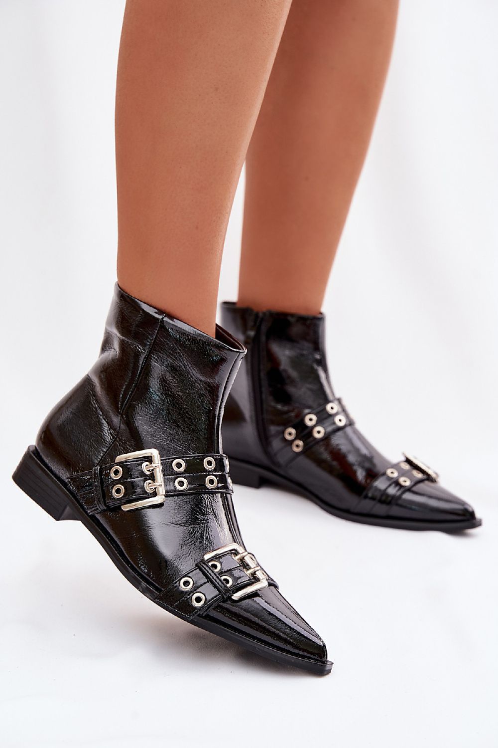 Black leather boots with silver buckles on a white background