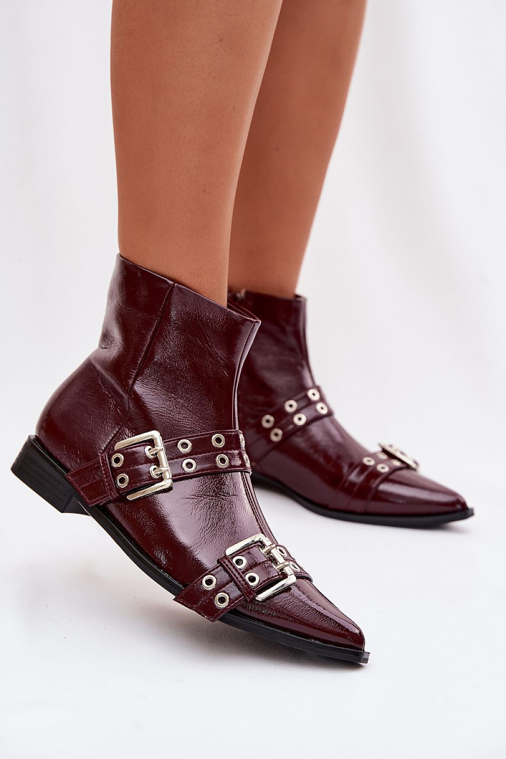 Brown leather boots with gold buckles on a white background