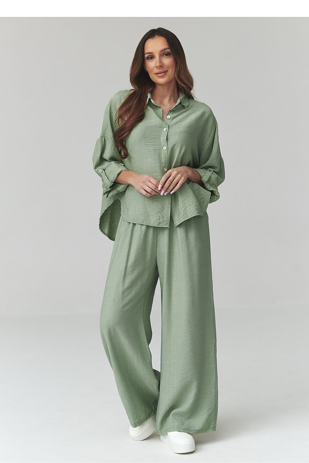 Woman wearing a green outfit on a plain background