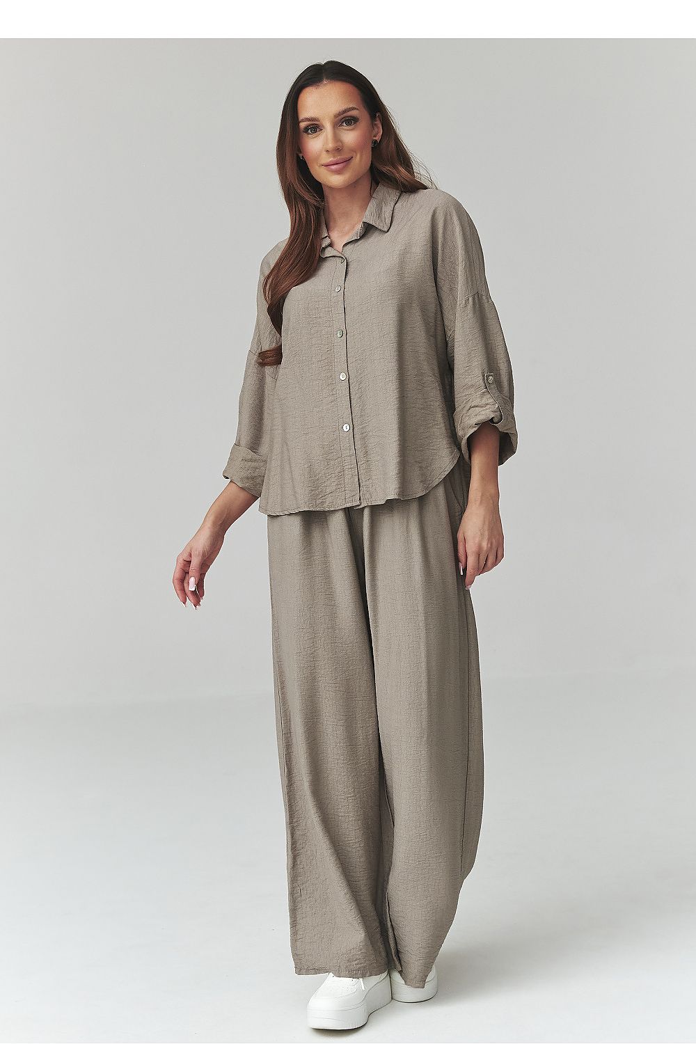 Woman wearing a beige outfit on a white background