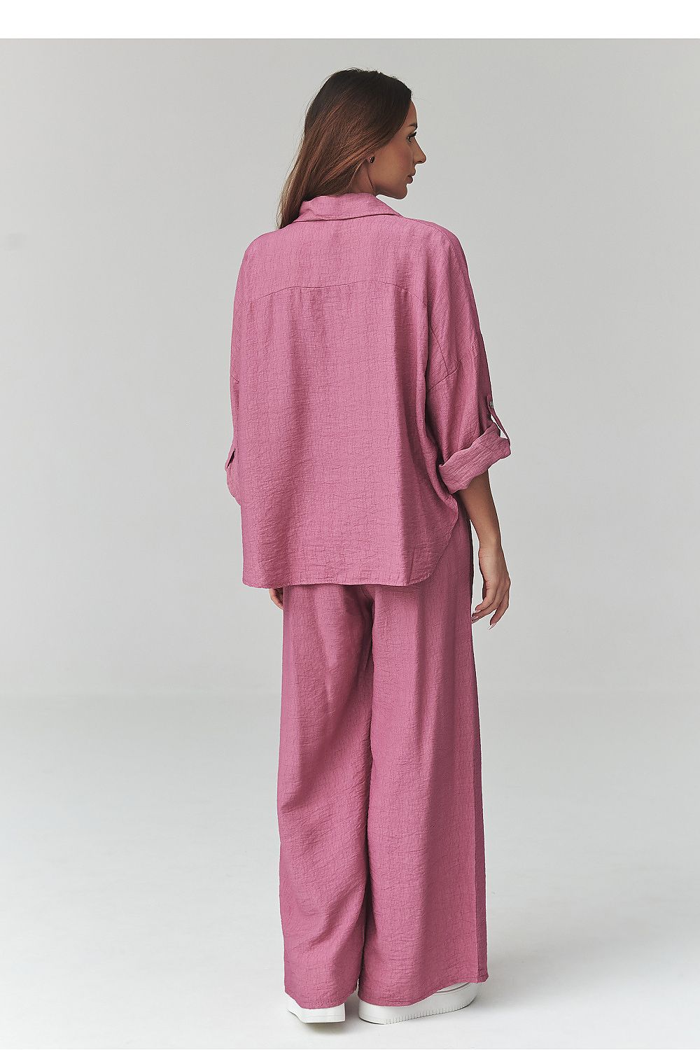 Woman wearing a pink outfit on a white background