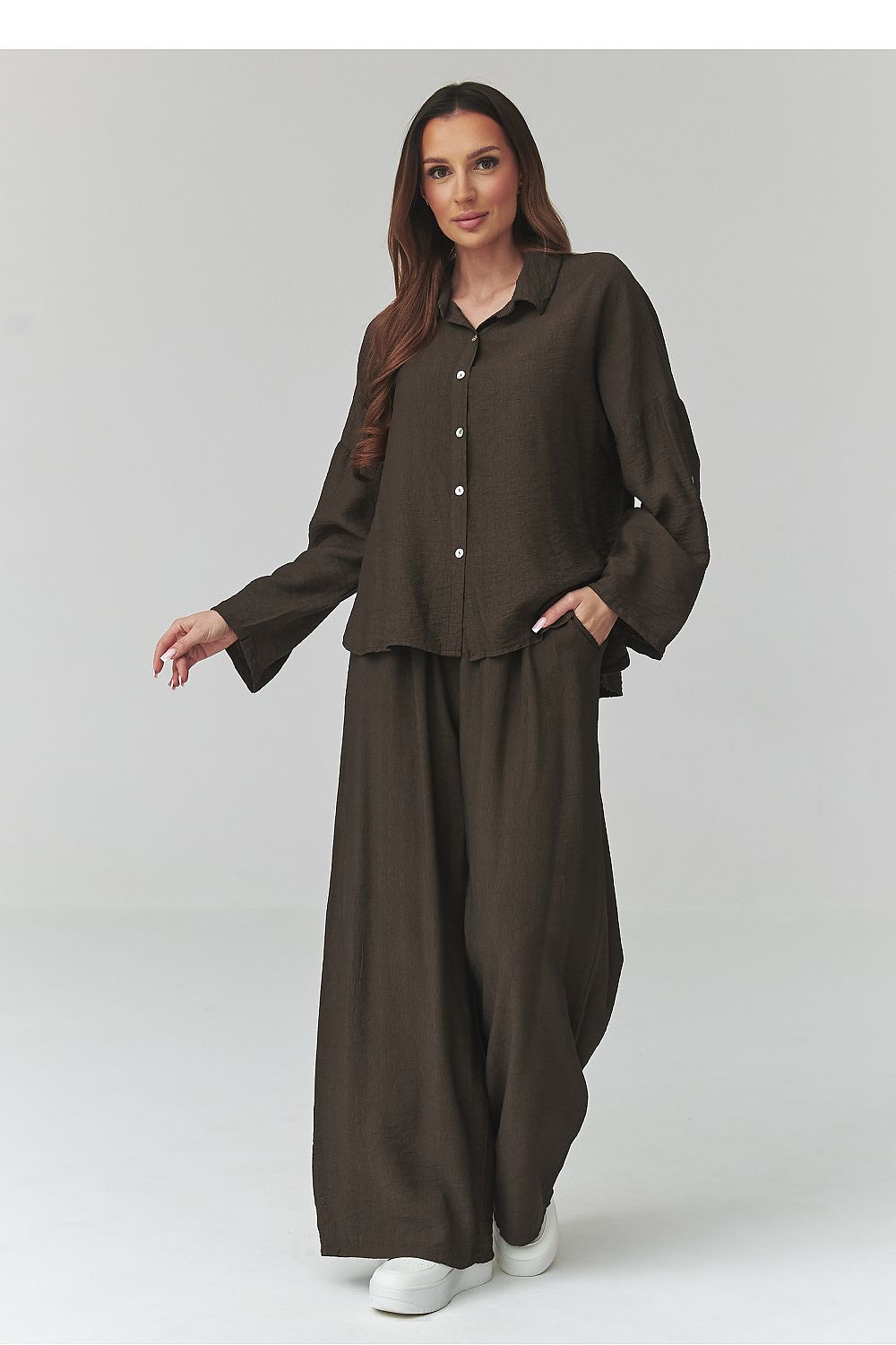 Woman wearing a brown outfit on a gray background