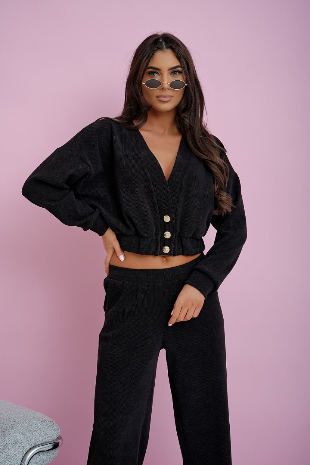 Woman wearing a black outfit with a pink background