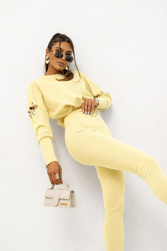 Woman in a yellow outfit posing against a white background