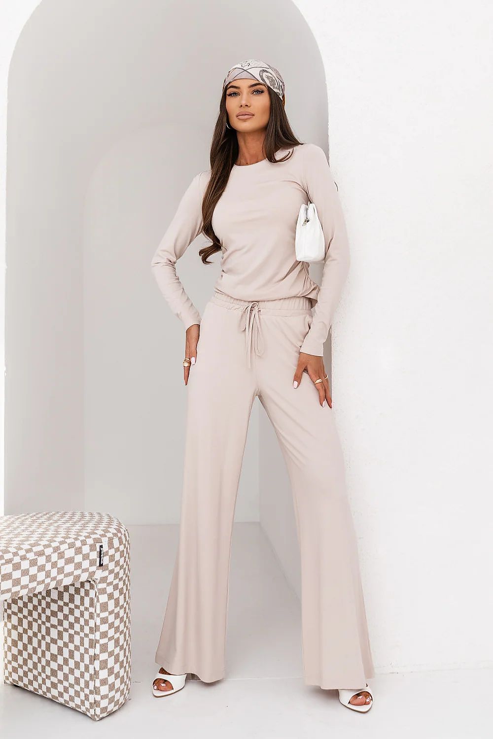 Woman in a beige outfit with a white background