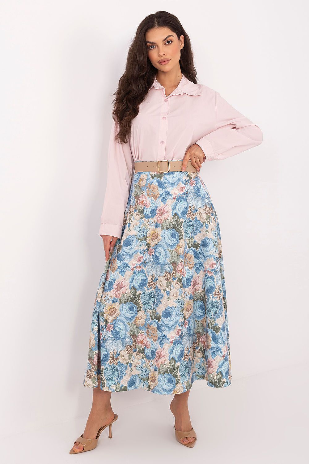Woman wearing a pink blouse and floral skirt on a white background