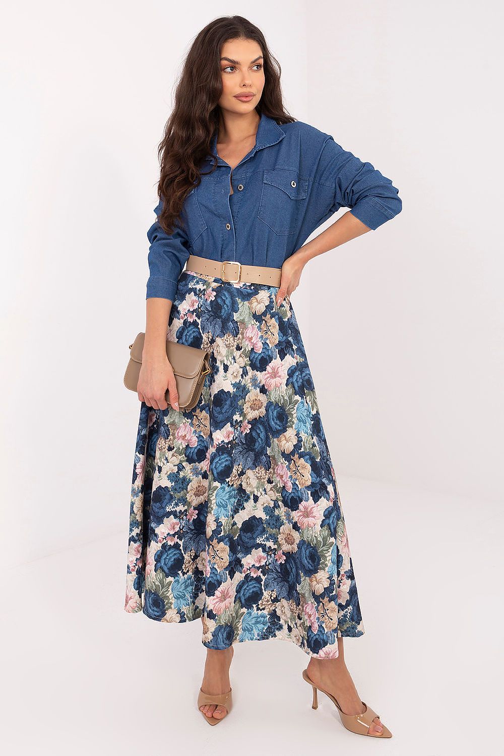 Woman wearing a denim shirt and floral skirt on a white background