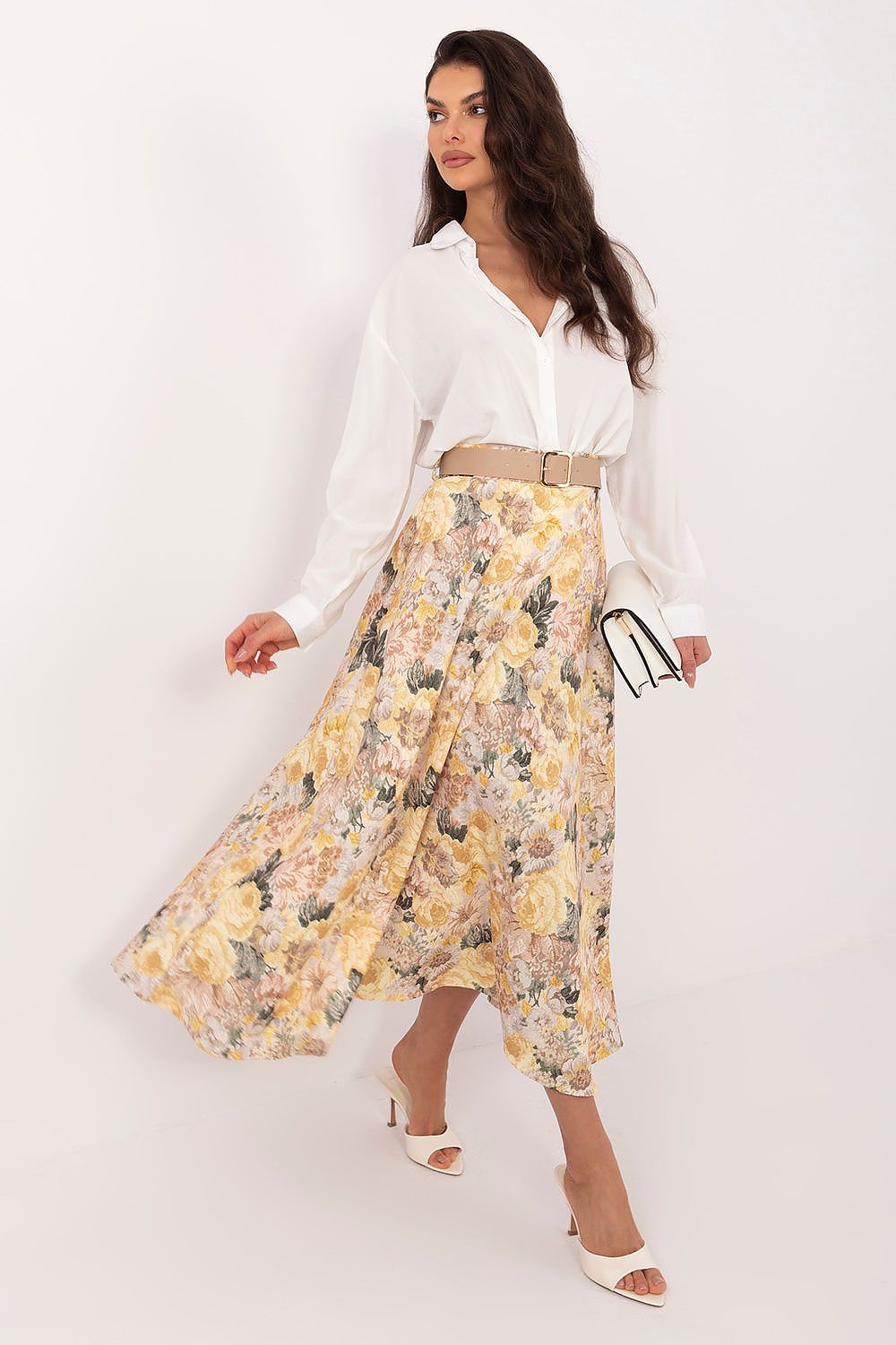 Woman wearing a white blouse and yellow floral skirt on a white background