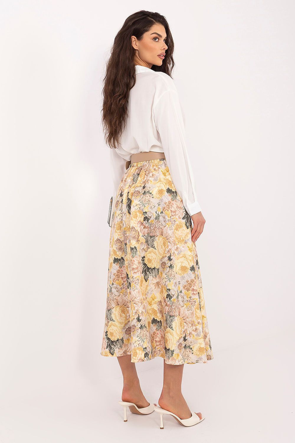 Woman wearing a white blouse and floral skirt on a white background