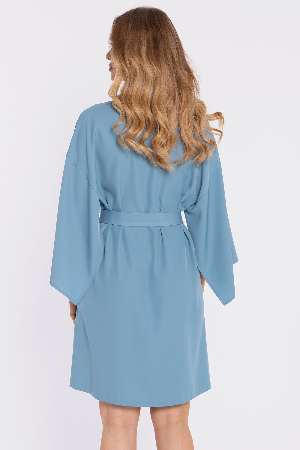 Woman wearing a light blue robe on a white background
