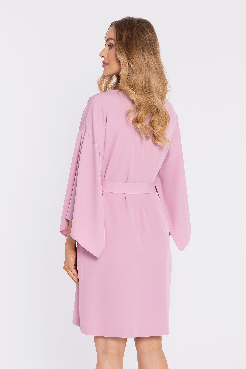 Woman wearing a pink robe against a white background