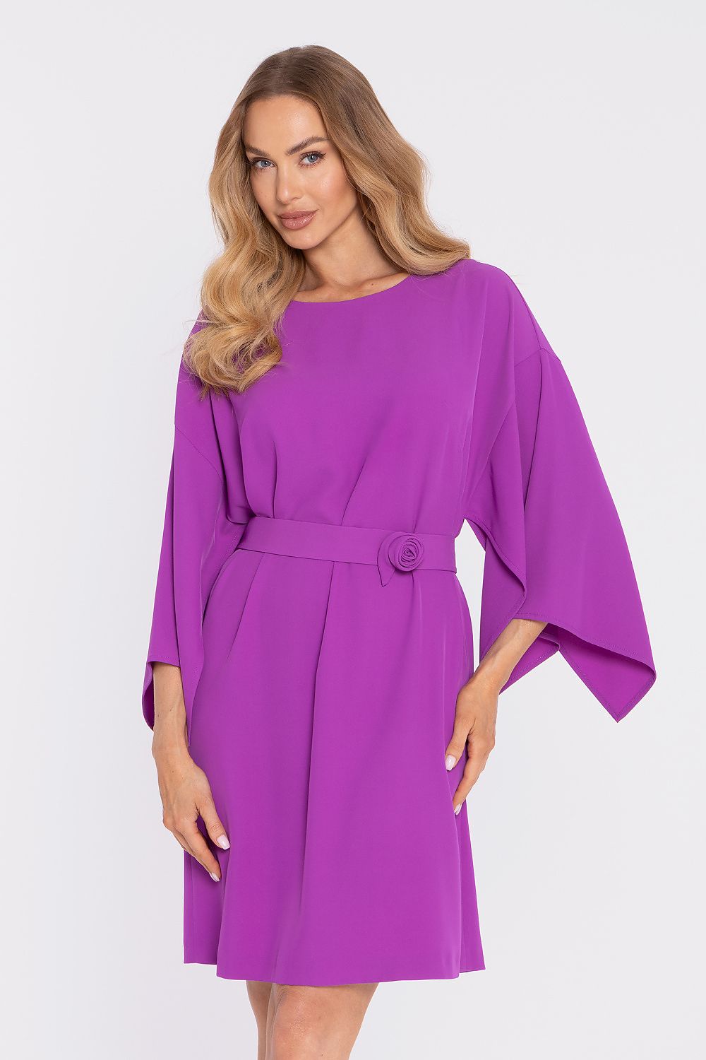 Woman wearing a purple dress with a belt on a white background
