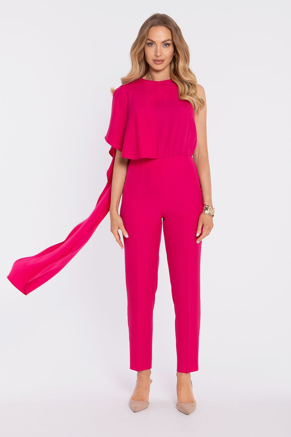 Woman wearing a bright pink jumpsuit on a white background