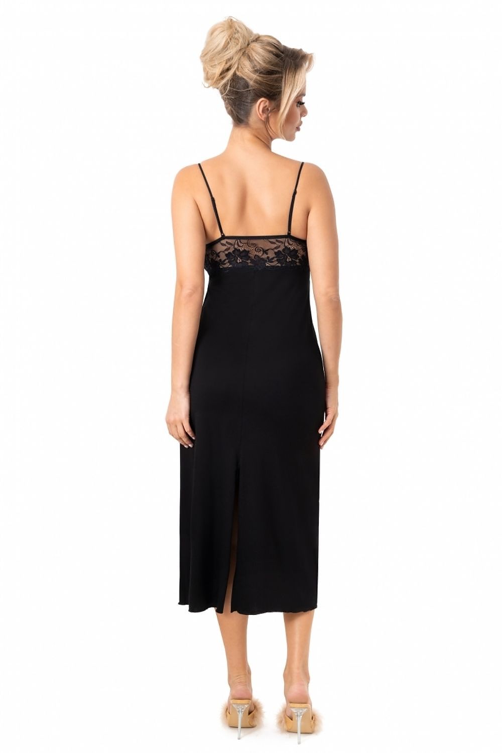 Woman wearing a black slip dress with lace detailing on a white background