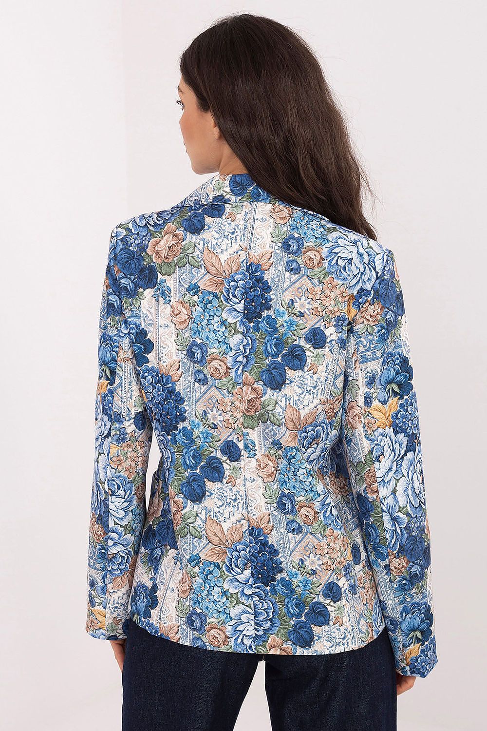 Woman wearing a blue floral patterned jacket on a white background