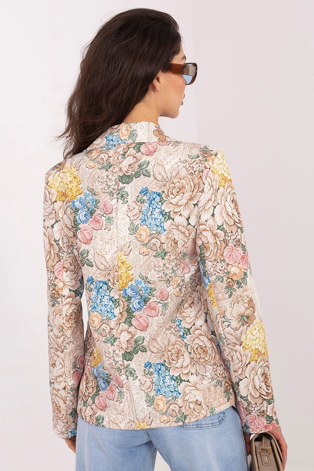 Woman wearing a floral blouse with a plain background