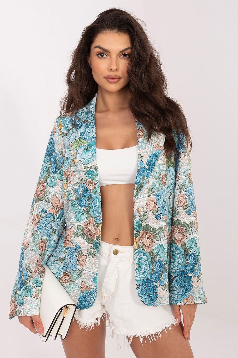 Woman wearing a floral jacket over a white top and shorts on a white background