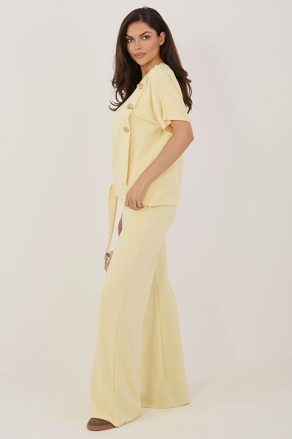 Woman wearing a light yellow outfit on a white background
