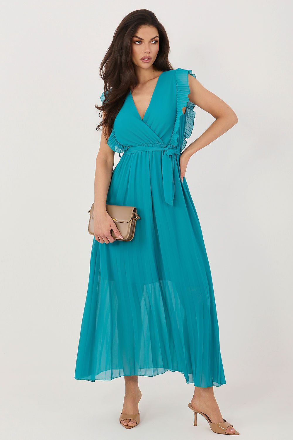 Woman wearing a teal dress with ruffled sleeves on a white background