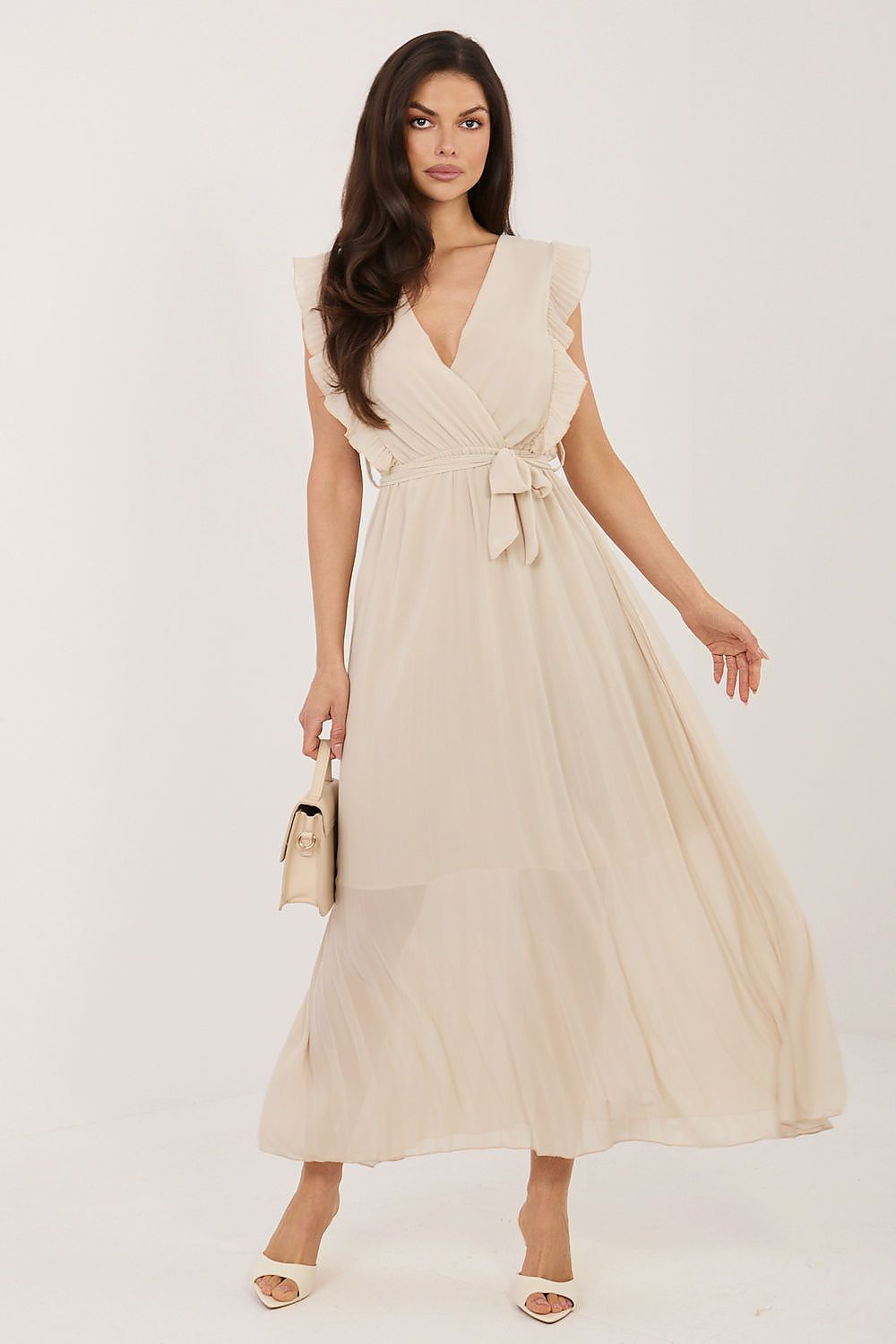 Woman wearing a beige dress with a plain background