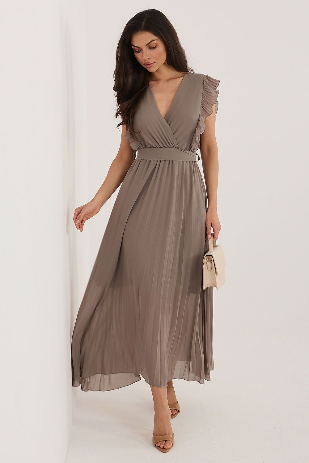 Woman wearing a brown dress with a plain background