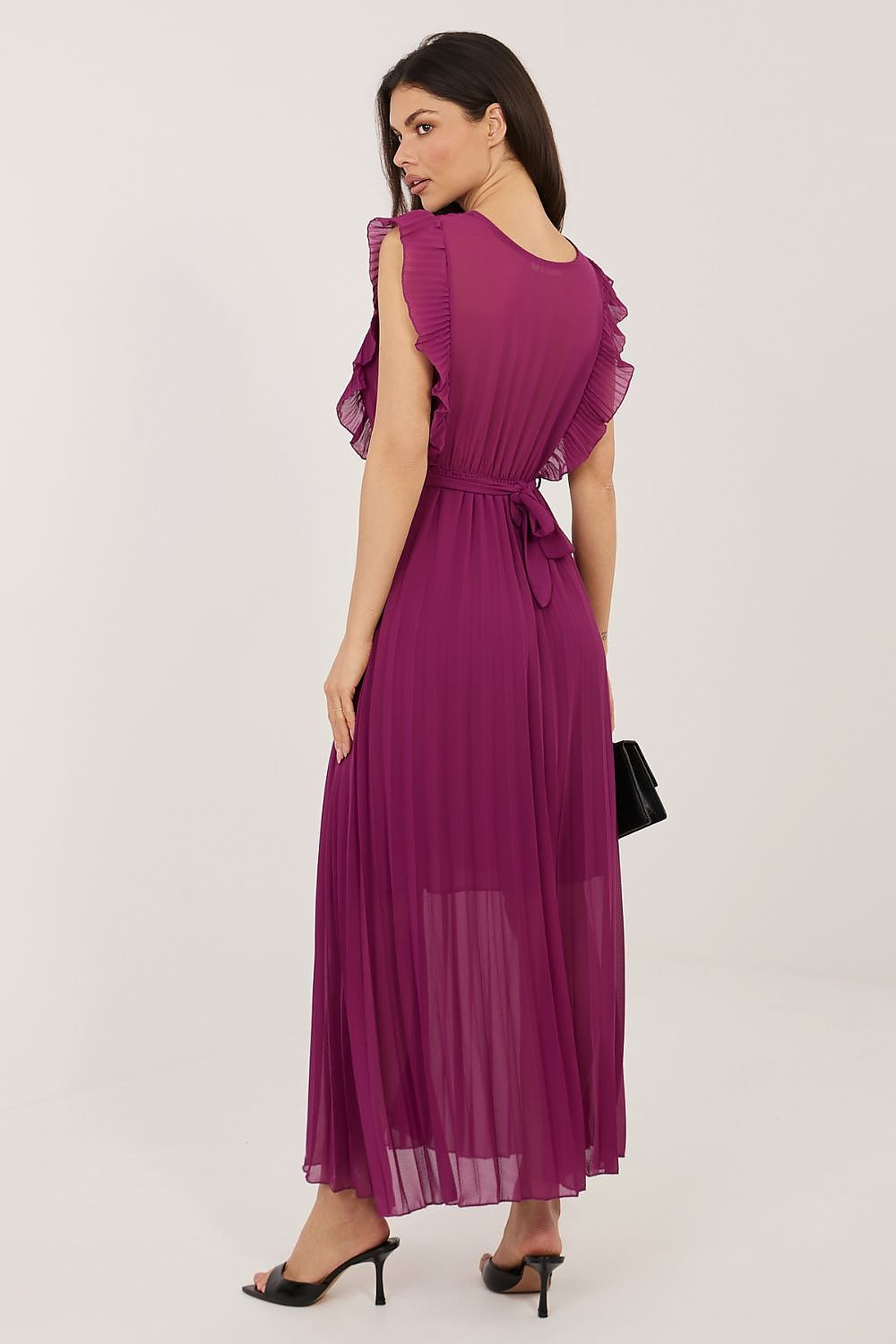 Woman wearing a purple dress with ruffled sleeves on a white background