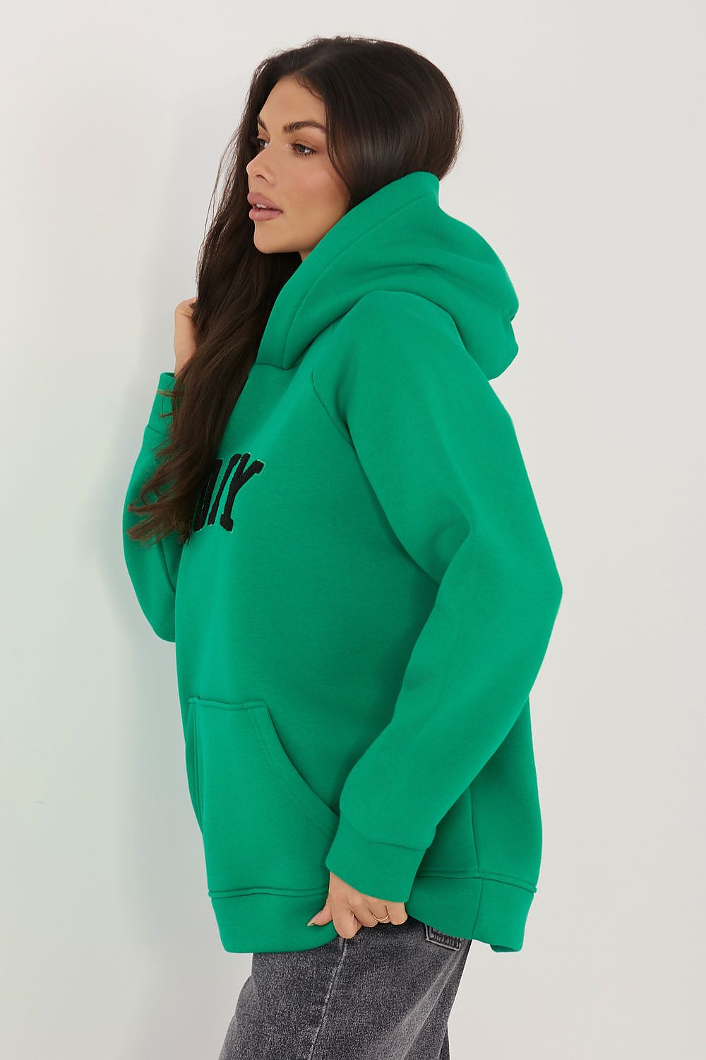 Woman wearing a green hoodie with text on a white background