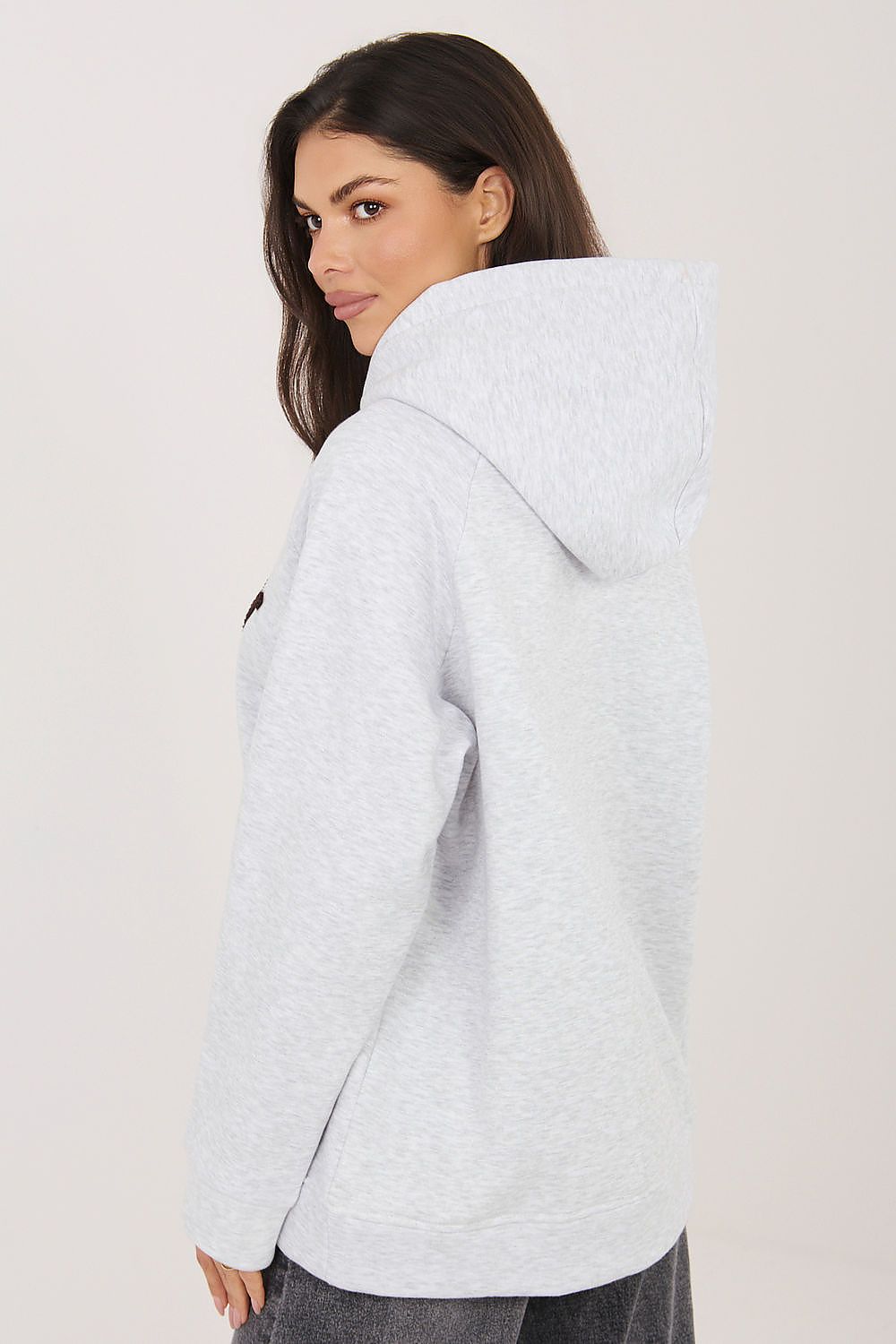 Woman wearing a light gray hoodie with a blurred background