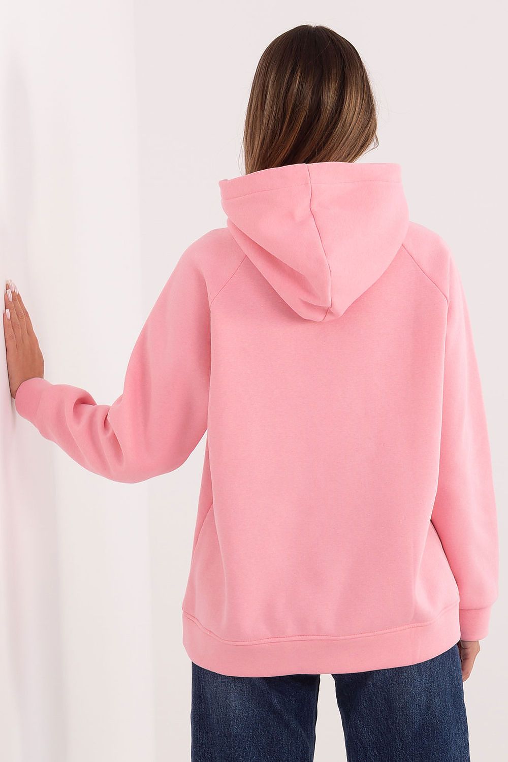 Person wearing a pink hoodie from behind on a white background