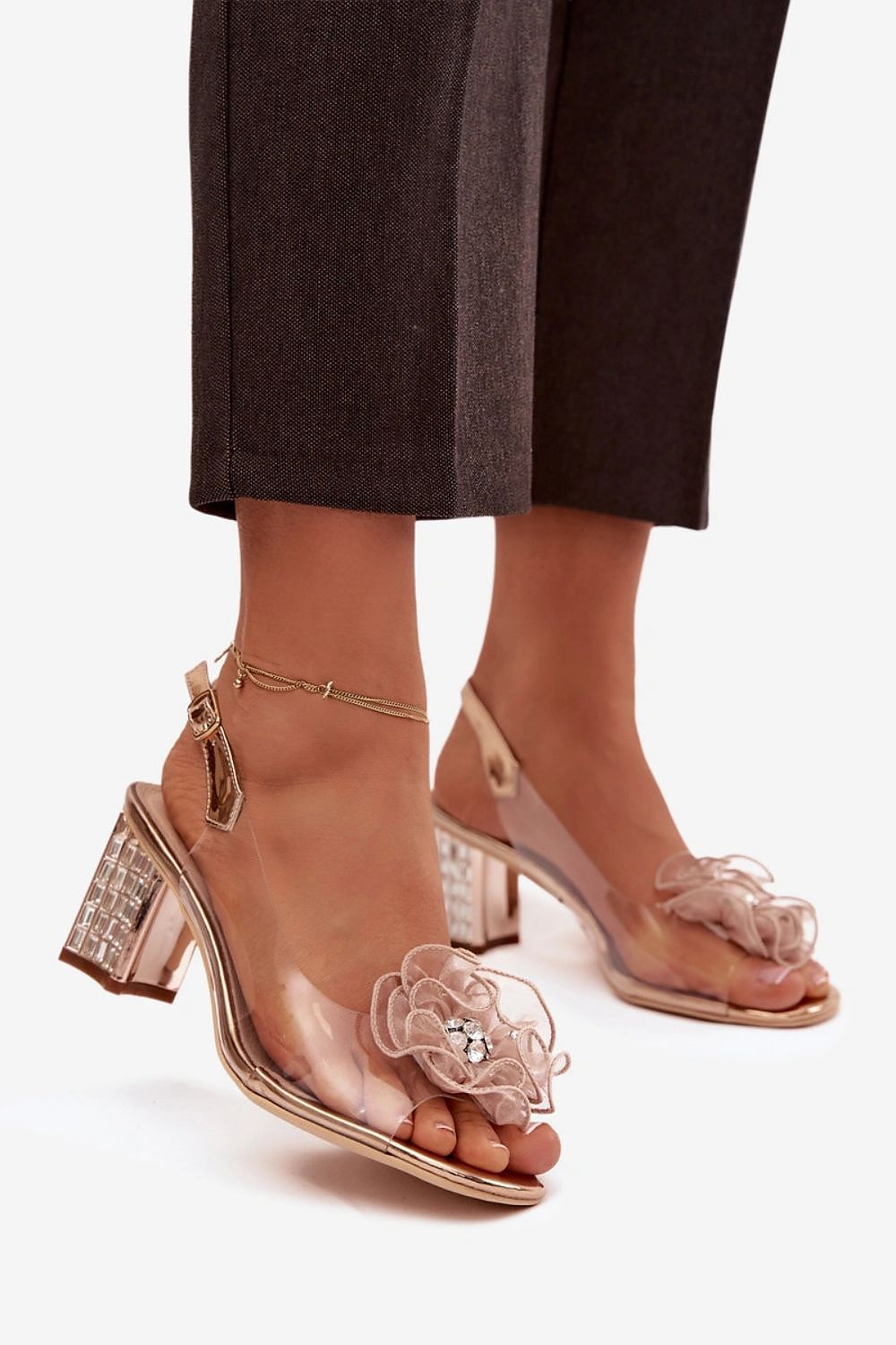 Clear high-heeled sandals with floral designs on a white background