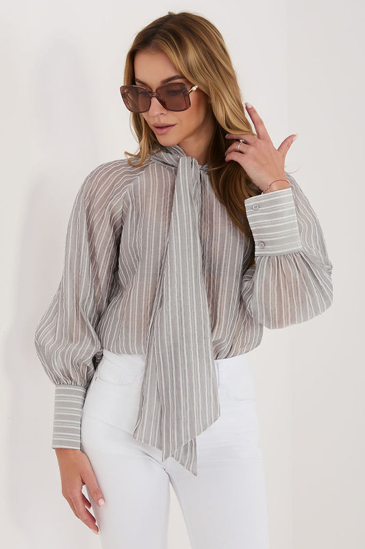 Woman wearing a striped blouse and sunglasses on a white background