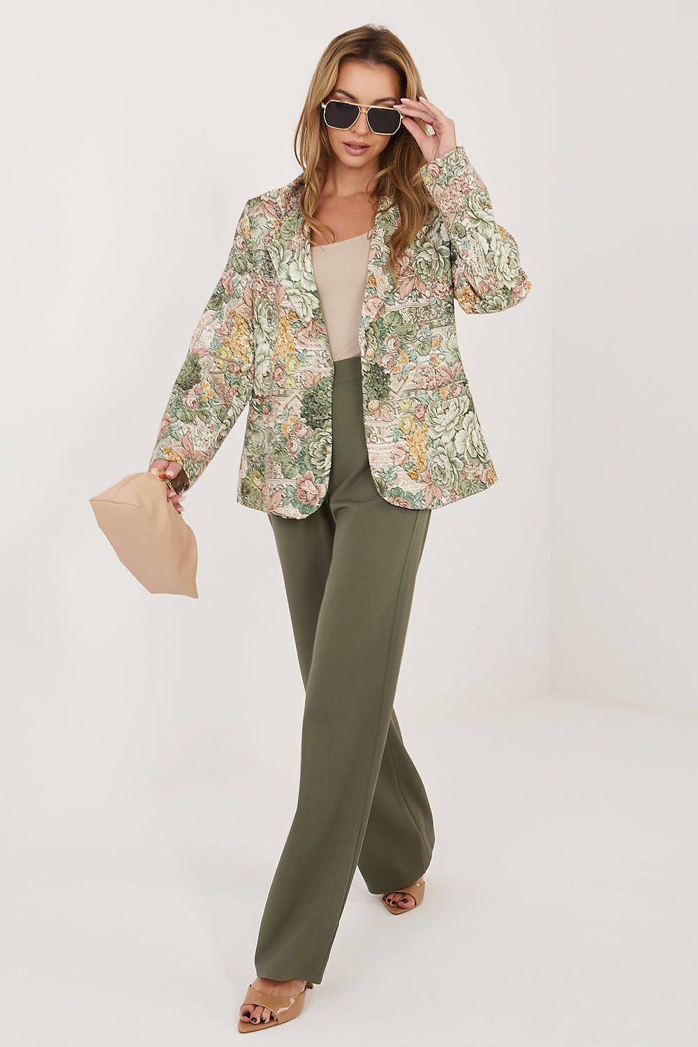 Woman wearing a floral jacket and green pants on a white background