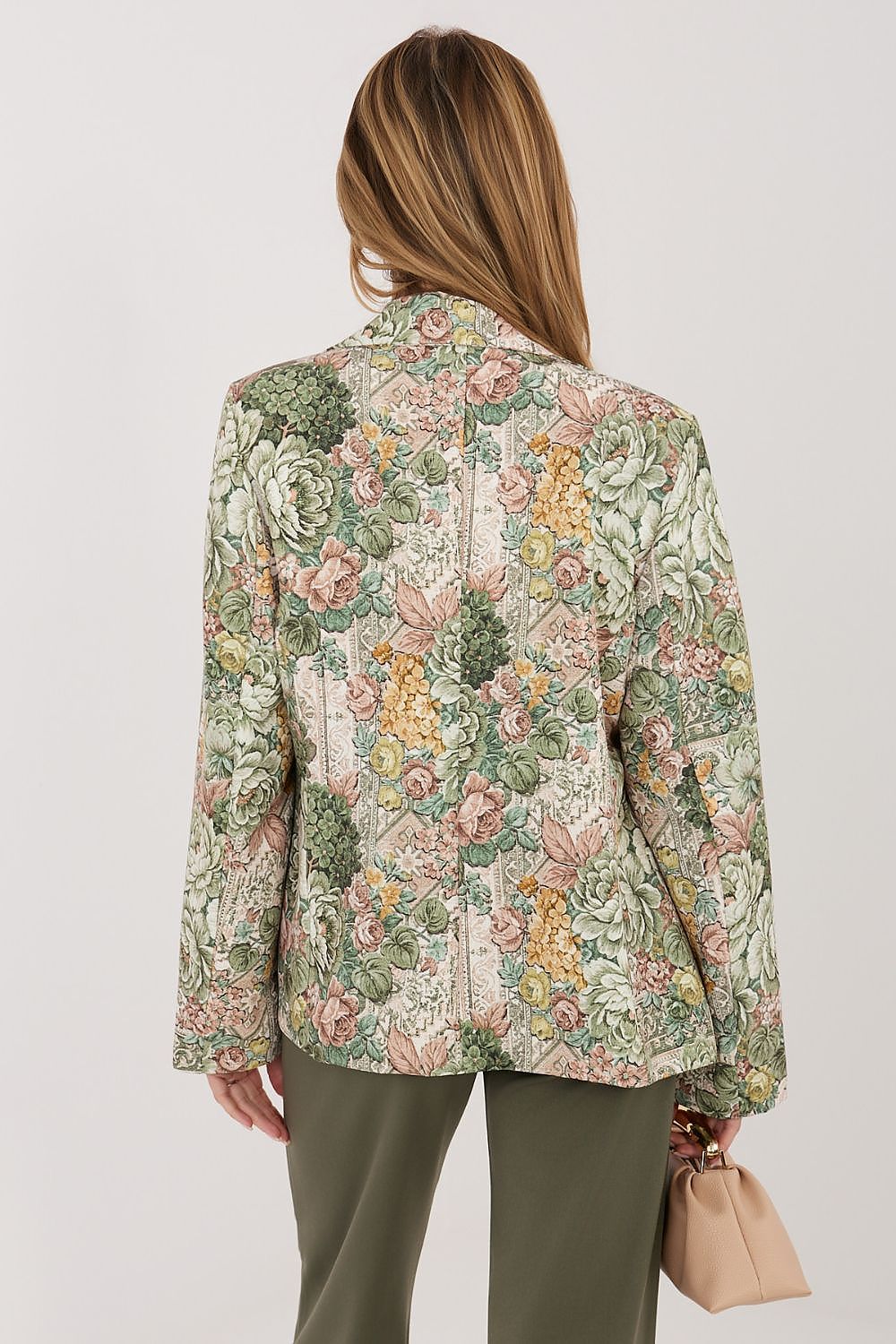 Woman wearing a floral patterned jacket on a plain background