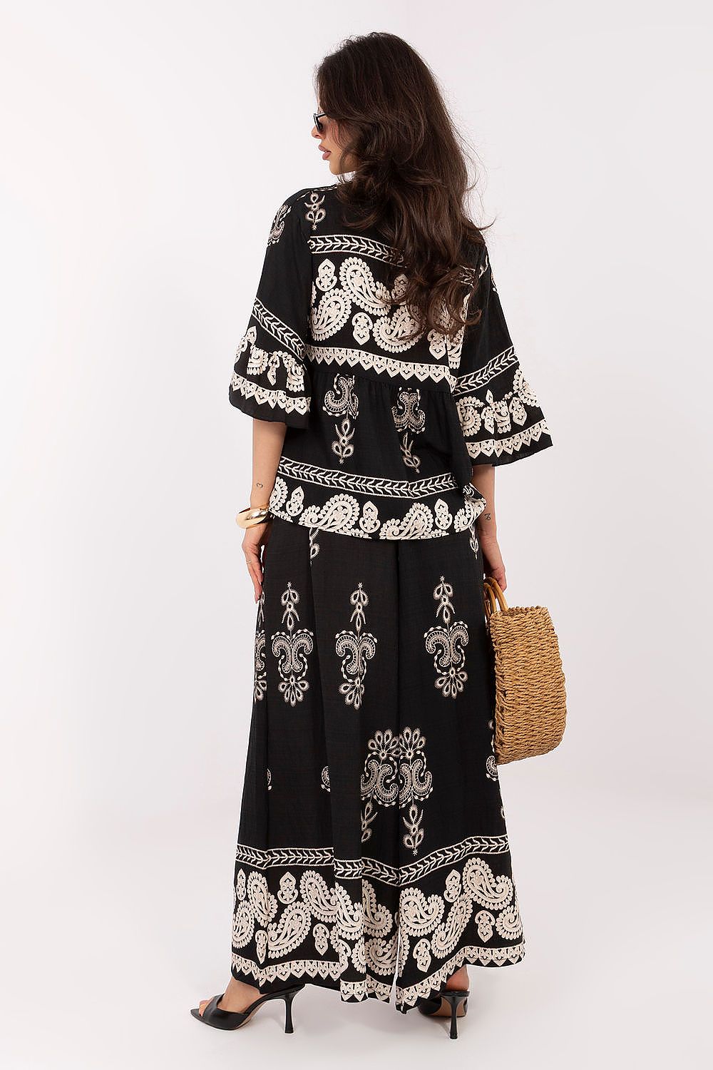 Woman wearing a black and white patterned dress on a white background