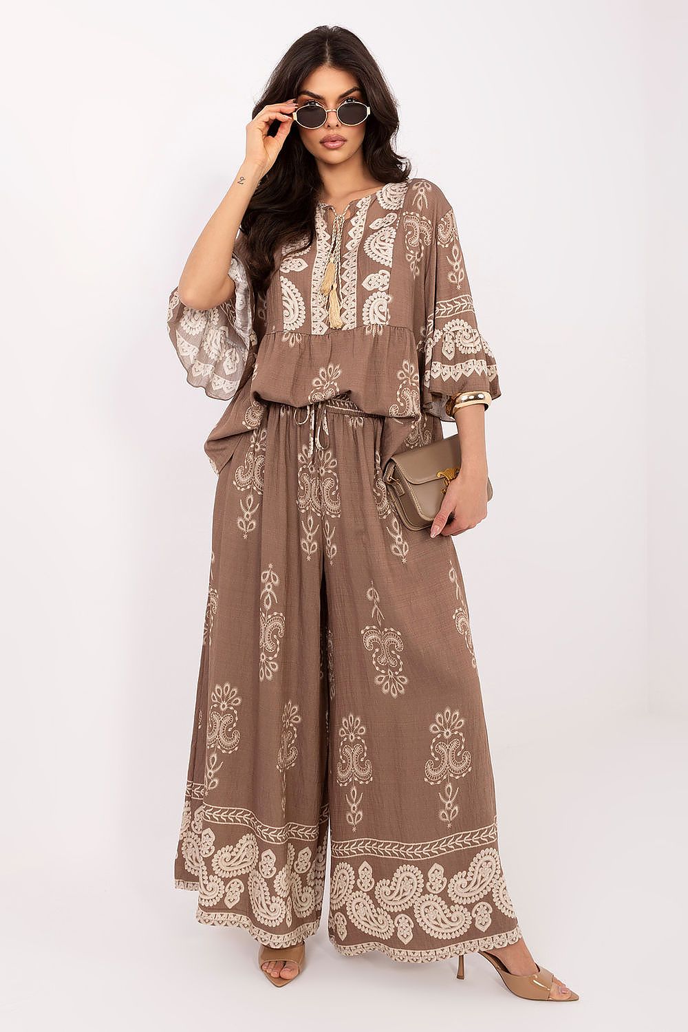 Woman wearing a brown and white patterned outfit on a white background