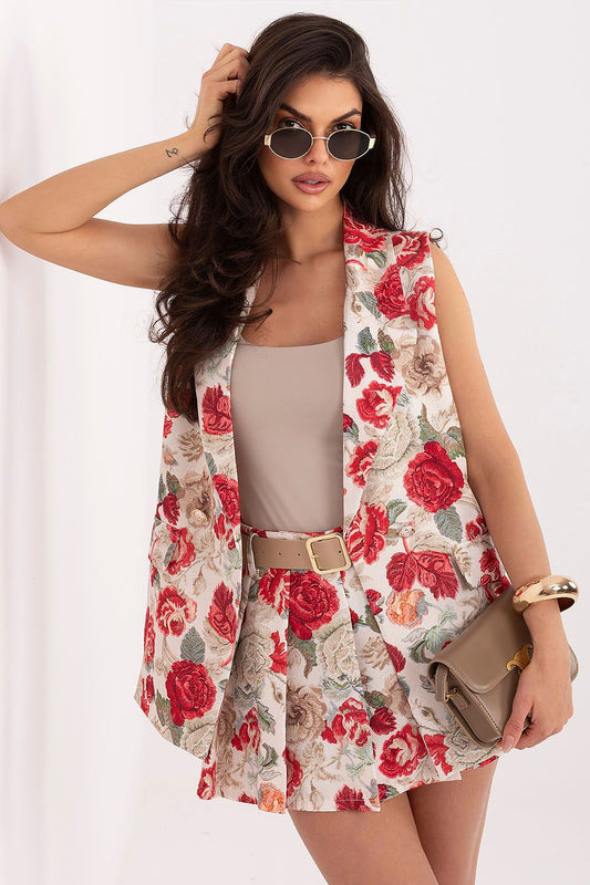 Woman wearing a floral vest over a dress with sunglasses on a white background