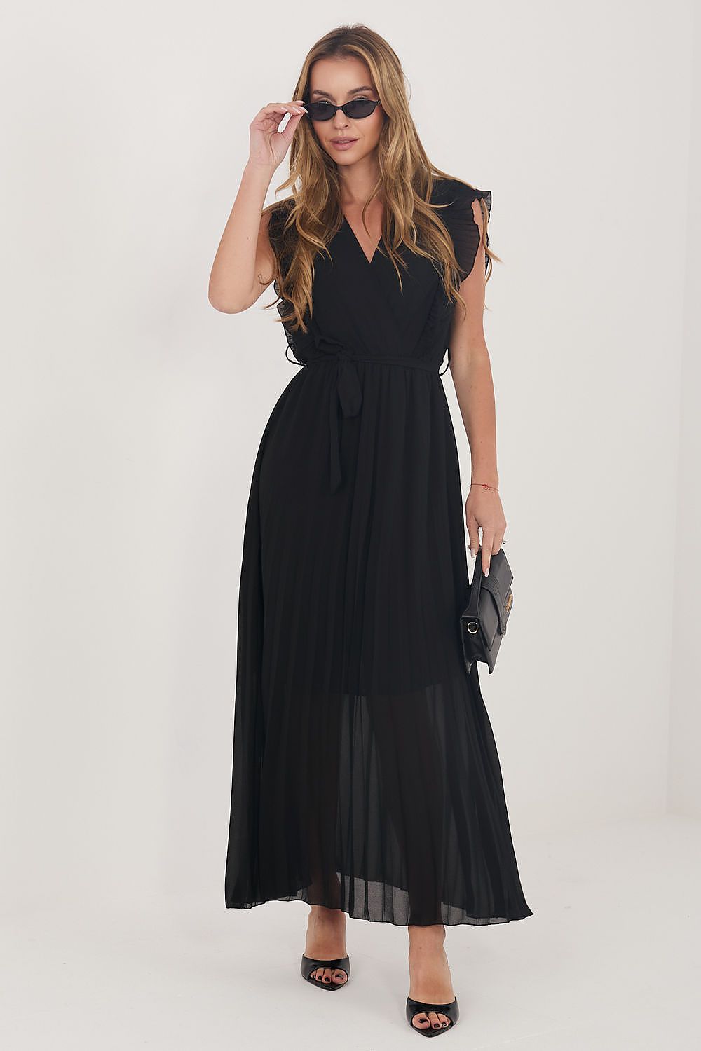 Woman wearing a black dress with sunglasses on a white background