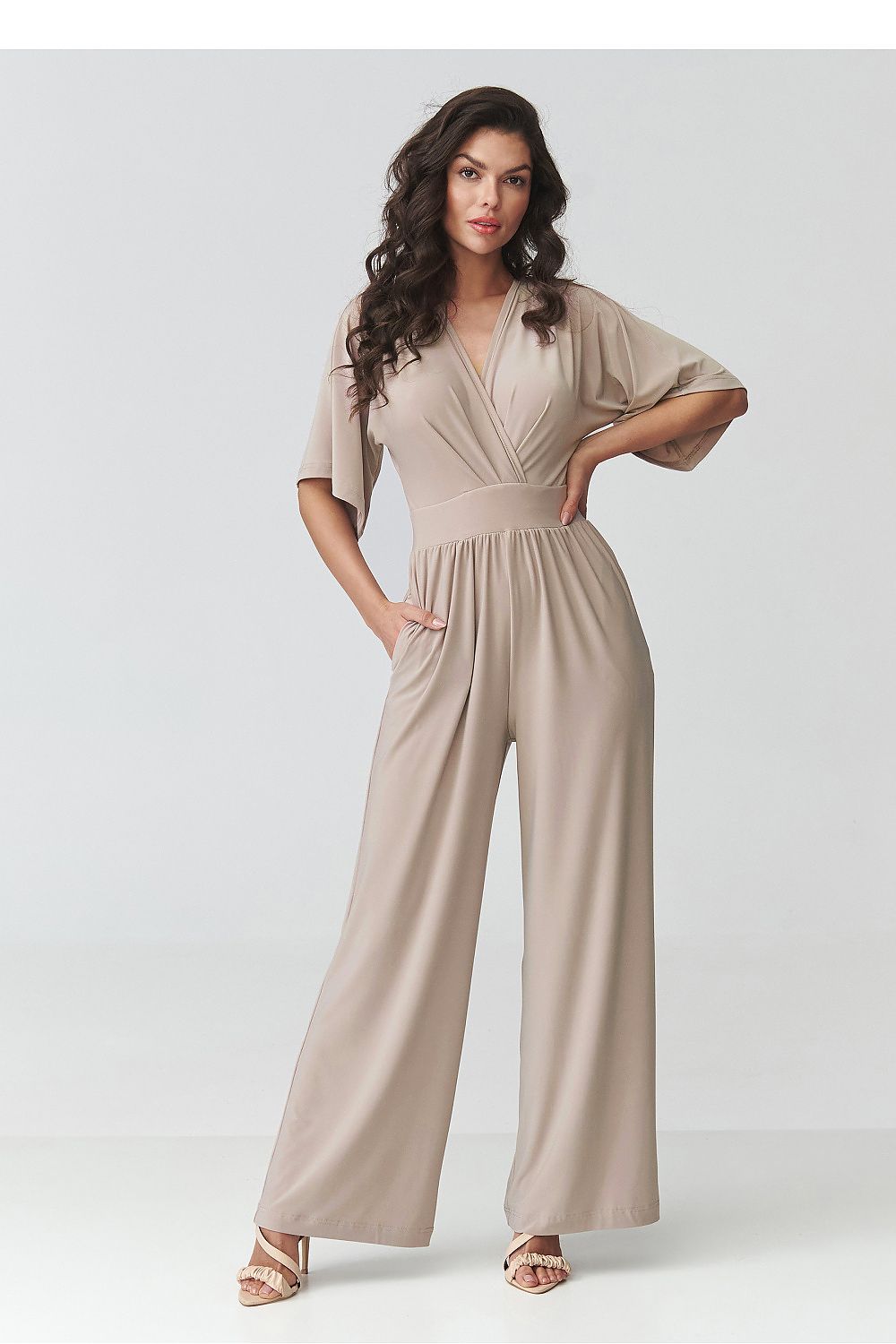 Woman wearing a beige jumpsuit on a white background