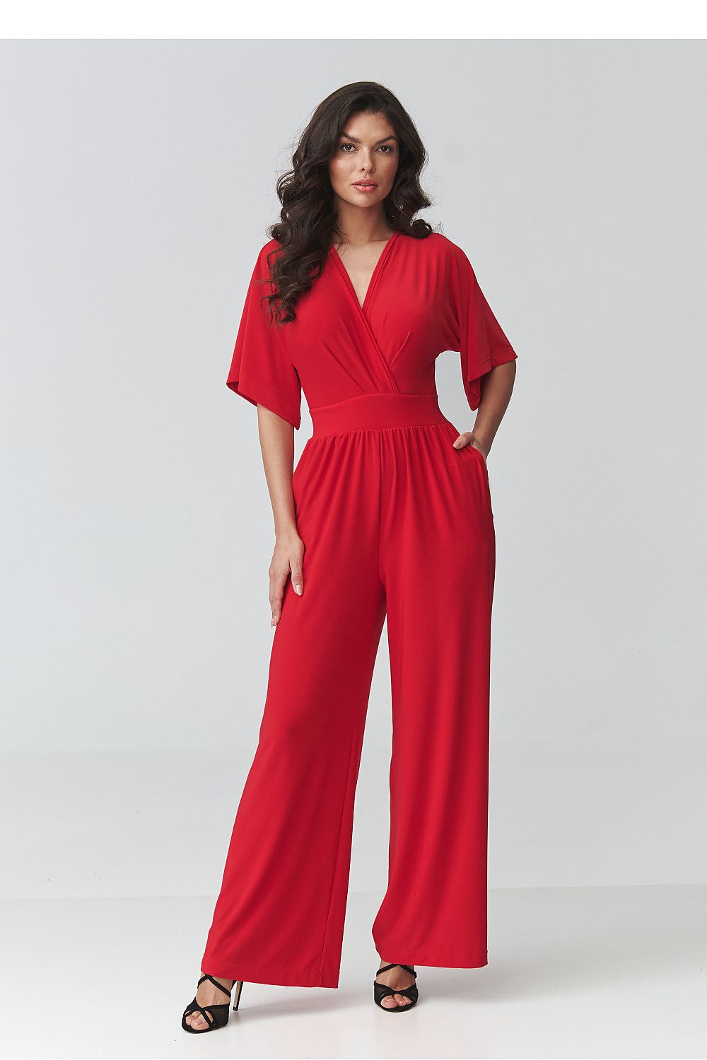Woman wearing a red jumpsuit on a white background