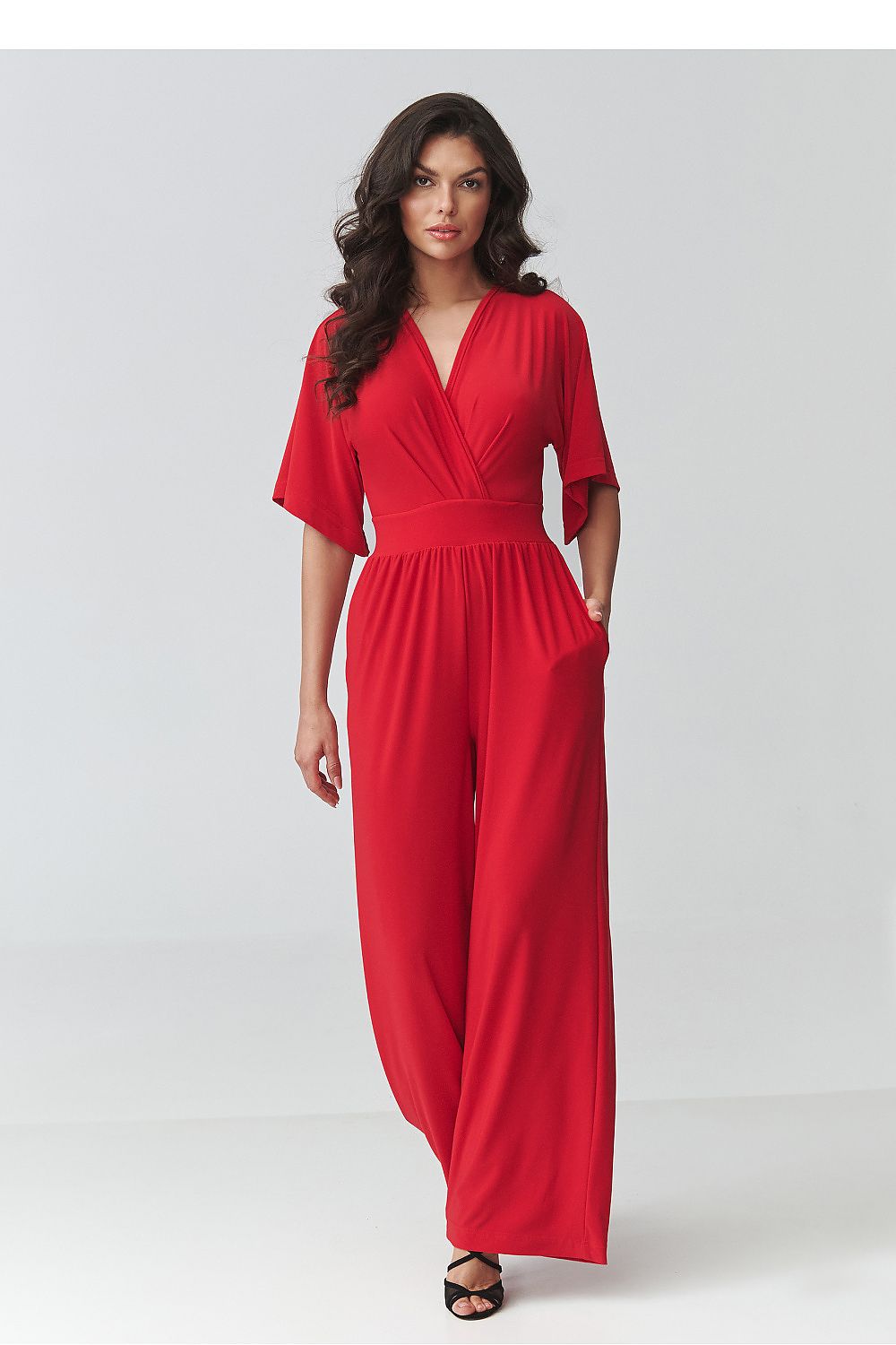 Woman wearing a red jumpsuit on a white background