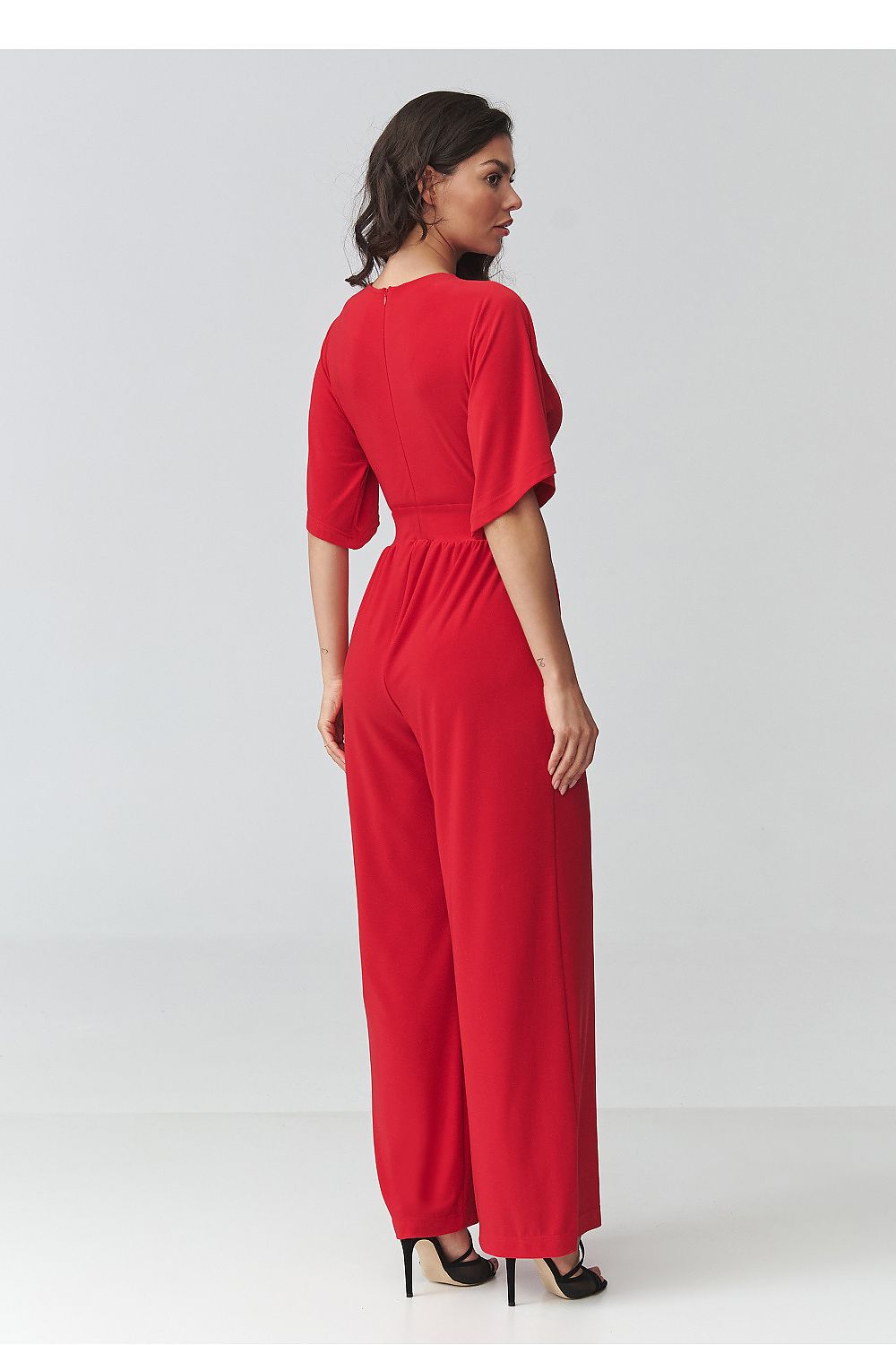 Woman wearing a red jumpsuit on a white background